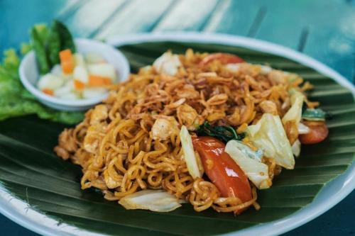a plate of food with noodles on a banana leaf at Peti Mas Hotel Malioboro in Yogyakarta