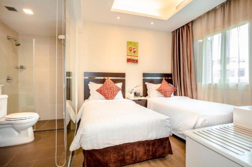 a hotel room with two beds and a toilet at Link Hotel Singapore in Singapore