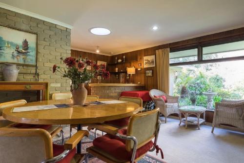 uma sala de estar com uma mesa de madeira e cadeiras em VILLABAYVIEW SPACIOUS Stay em Rosebud