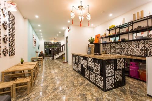 a restaurant with a counter and tables and chairs at Sunny Riverside Homestay in Hoi An