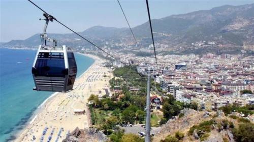 a gondola flying over a beach and the ocean at Riviera Zen Hotel Adult Only in Alanya