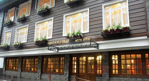 a building with windows and potted plants on it at Udaan Woodberry Hotel & Spa in Gangtok