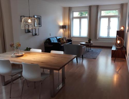 a living room with a wooden table and chairs at B&B Appartementen Engelenhof in Stevensweert