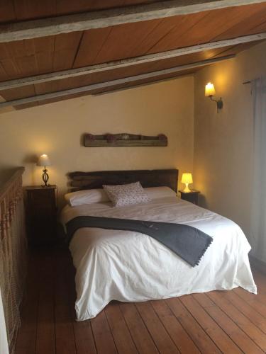 a bedroom with a large bed with a wooden floor at El Jardín Secreto in Orés