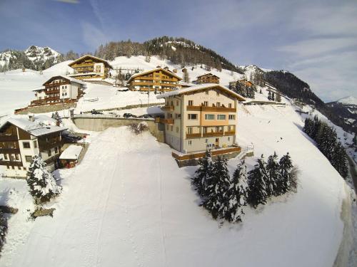a group of buildings on a snow covered mountain at Garni Bellavista in Arabba