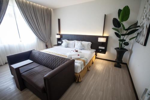 a living room with a bed and a couch at Amamas Boutique Hotel Kuching in Kuching