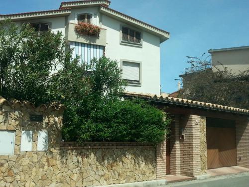 a large white house with a stone wall at Marco's house in Dolianova