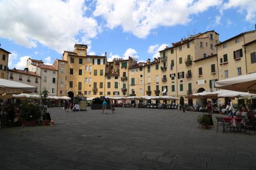 een groep gebouwen met tafels en stoelen op een binnenplaats bij Perle d'Ambra in Lucca
