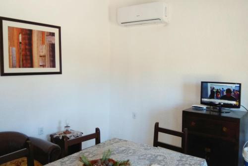 sala de estar con mesa y TV en la pared en Nuestro Sueño Ocean Park, en Sauce de Portezuelo