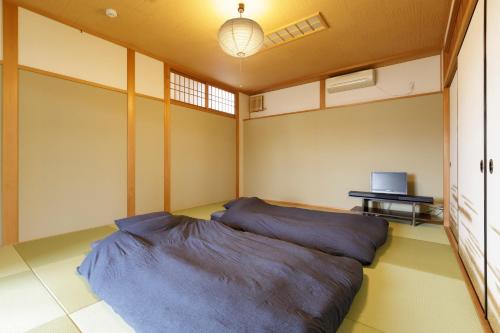 uma cama grande num quarto com um computador portátil sobre uma mesa em 日照庵 Nisshouan em Quioto