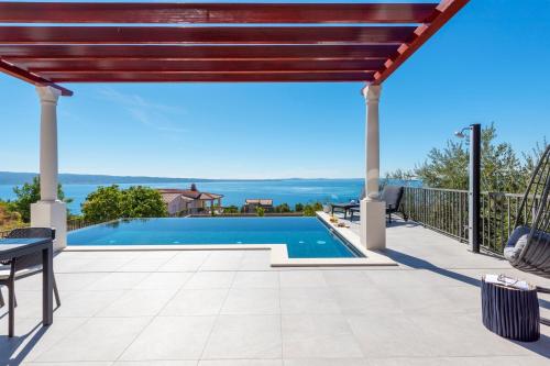 a view of a swimming pool from a patio of a house at A brand NEW VILLA - Infinity in Podstrana