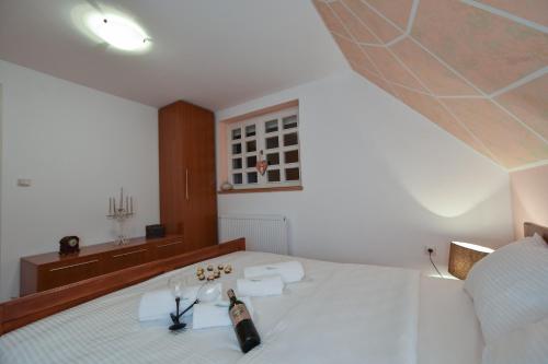 a room with a bed with a bottle and glasses at Villa Mira in Mačkat