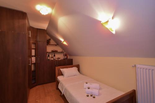 a small bedroom with a bed and lights on the ceiling at Villa Mira in Mačkat