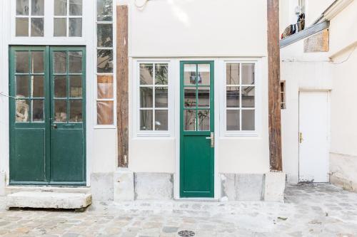 une porte verte sur le côté d'un bâtiment dans l'établissement Le Loft du Marais, à Paris