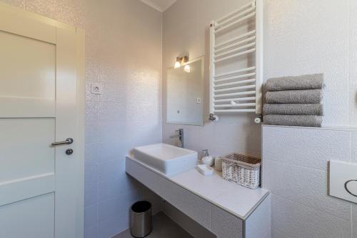 a white bathroom with a sink and a mirror at Villa Monique in Vodnjan