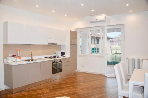 a kitchen with white cabinets and a table and a window at Terrazza San Giovanni apartment in Rome