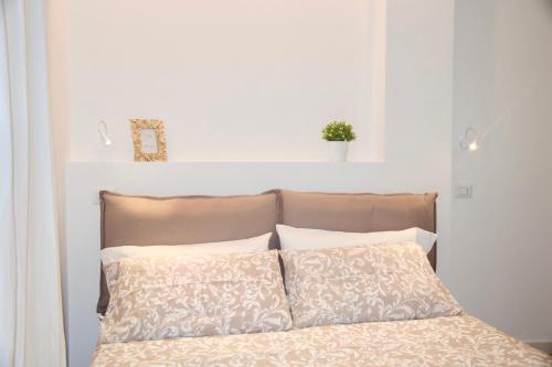 a bed with two pillows and a white wall at Terrazza San Giovanni apartment in Rome