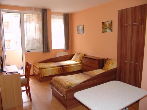 ヴェリコ・タルノヴォにあるOur Home Guest Roomsのベッドルーム1室(ベッド2台、椅子、テーブル付)