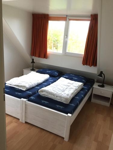 スカーレンデイケにあるFerienhaus Nordseeliebeの窓が2つある部屋にベッドが2つある