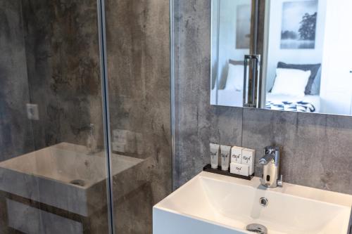 a bathroom with a sink and a shower at Hajé Hotel Restaurant de Lepelaar in Lelystad