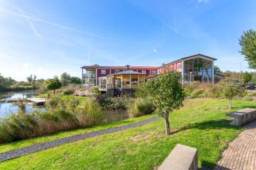 a house on a hill next to a river at Hajé Hotel Restaurant de Lepelaar in Lelystad