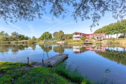 a house on a lake with a dock at Hajé Hotel Restaurant de Lepelaar in Lelystad