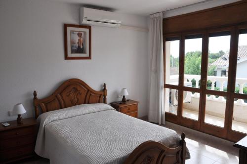 a bedroom with a bed and a large window at Tenis Roda de Bara in Roda de Bará