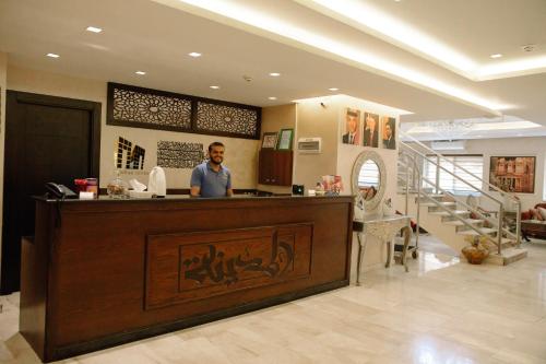 un homme debout à un comptoir dans un magasin dans l'établissement Madina Suites, à Amman