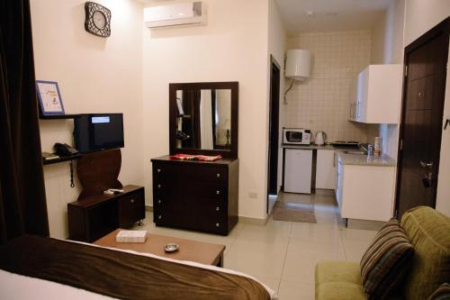 アンマンにあるMadina Suitesのリビングルーム(ソファ、テレビ付)、キッチン