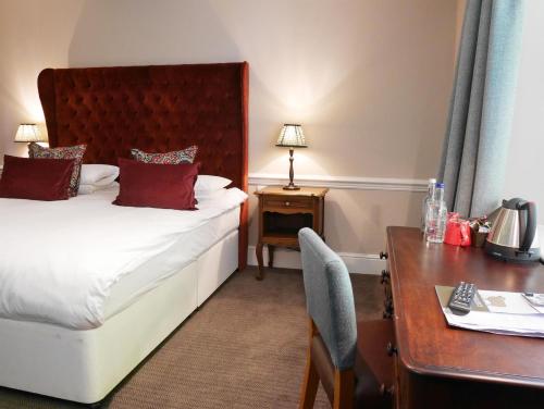 a hotel room with a bed and a desk and a desk at The Fleece in Witney