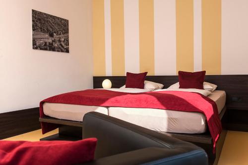 a bedroom with two beds and a couch at Hotel Grenzfall in Berlin