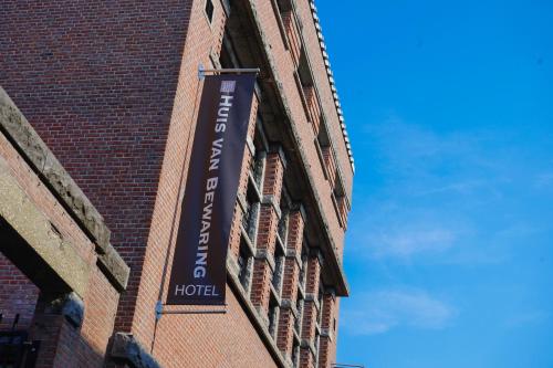 a hotel sign on the side of a brick building at Hotel Huis van Bewaring - Bijzonder boutique hotel in historisch pand in Almelo