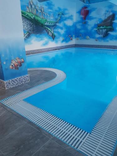 a swimming pool with a fish mural on the wall at Pasja in Świeradów-Zdrój