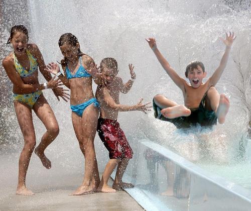 a group of children playing in a water fountain at Hytteby – Hanstholm Camping – Thy Feriepark in Hanstholm