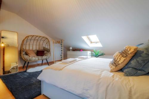 een slaapkamer met een bed met een stoel en een spiegel bij Belém Sweet Spot in Lissabon