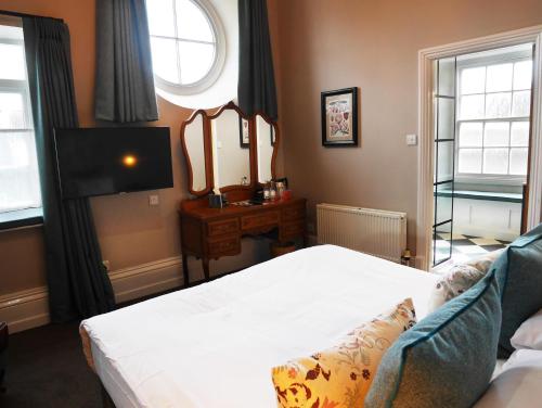 a bedroom with a white bed and a mirror at The Fleece in Witney