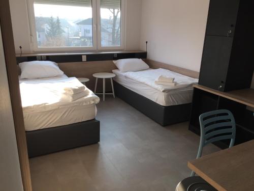 Habitación con 2 camas, mesa y ventana en Accommodation Vitalis en Liubliana