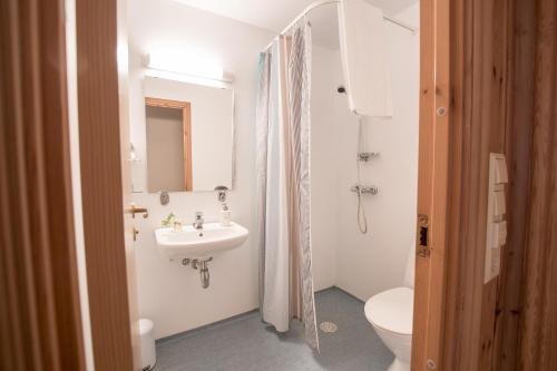 a white bathroom with a sink and a toilet at Tønsberg Vandrerhjem in Tønsberg