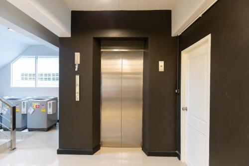 a elevator in a building with a black wall at Mango 10 House in Bangkok