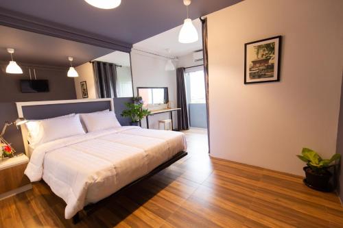 a bedroom with a large white bed in a room at Mango 10 House in Bangkok