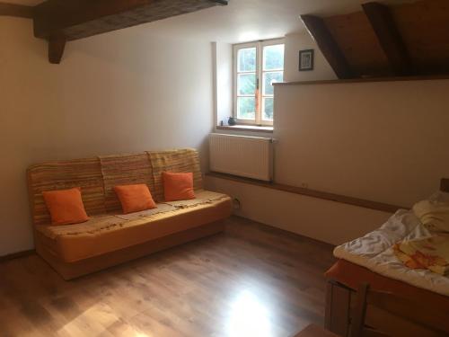 a living room with a couch and a window at Chalupa Continental in Ostružná