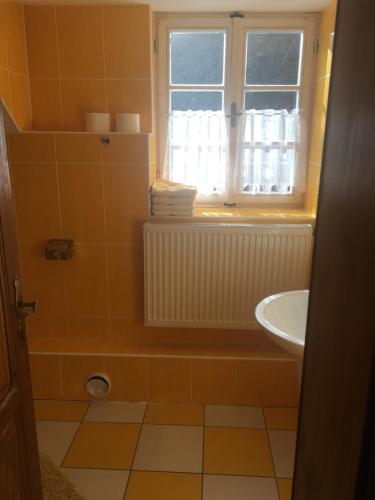 a bathroom with a sink and a toilet and a window at Chalupa Continental in Ostružná