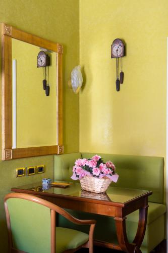 a room with a table with a basket of flowers on it at Art Hotel Orologio in Bologna