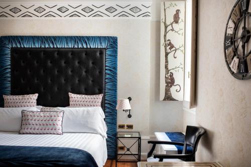 a bedroom with a bed with a blue headboard at Art Hotel Orologio in Bologna