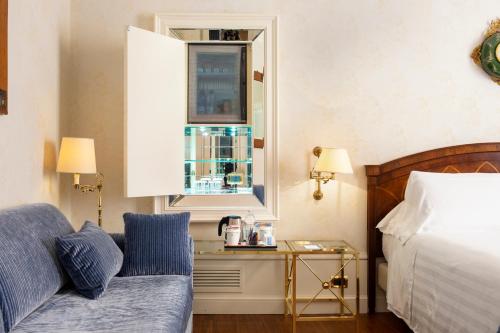 a bedroom with a bed and a couch and a window at Art Hotel Orologio in Bologna