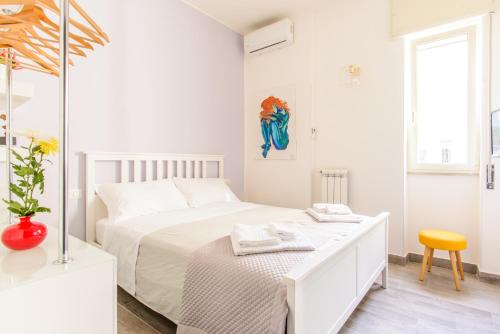 ナポリにあるMelisurgo Propertyの白いベッドルーム(白いベッド1台、黄色いスツール付)