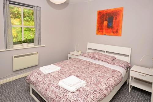 a bedroom with a bed with two towels on it at Cottage 315 - Clifden in Clifden