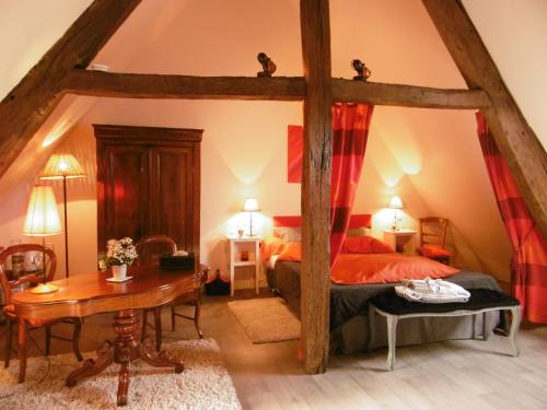 a bedroom with a bed and a table in a room at Manoir de L'Hermerel in Géfosse-Fontenay