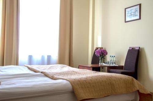a bedroom with a bed and a chair and a table at Centrum Okopowa 55 in Warsaw