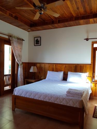 a bedroom with a bed with a ceiling fan at Free Beach Resort in Phu Quoc